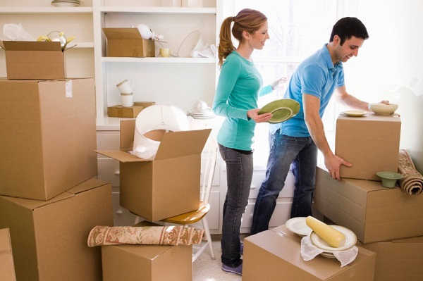 hai người đang đóng gói vật dụng trước khi chuyển nhà
